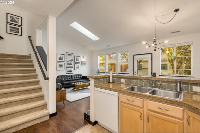 living room with vaulted ceiling with skylight, a notable chandelier, and light hardwood / wood-style flooring