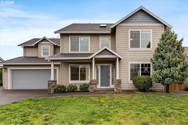 craftsman house featuring a front yard and a garage