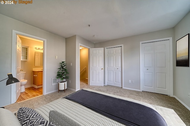 carpeted bedroom with connected bathroom and multiple closets