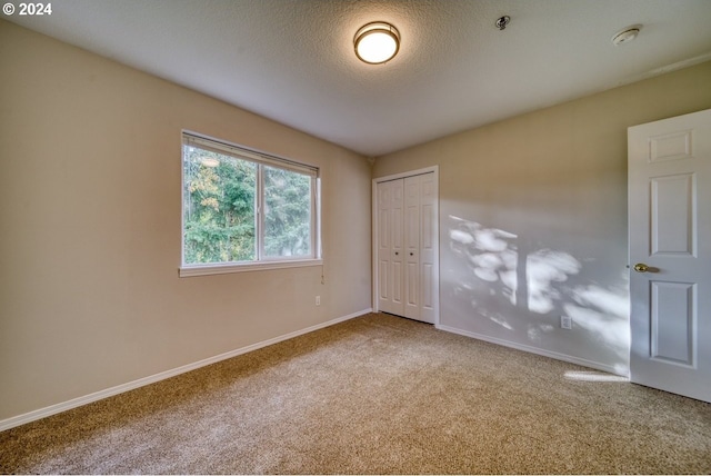 carpeted spare room featuring a textured ceiling