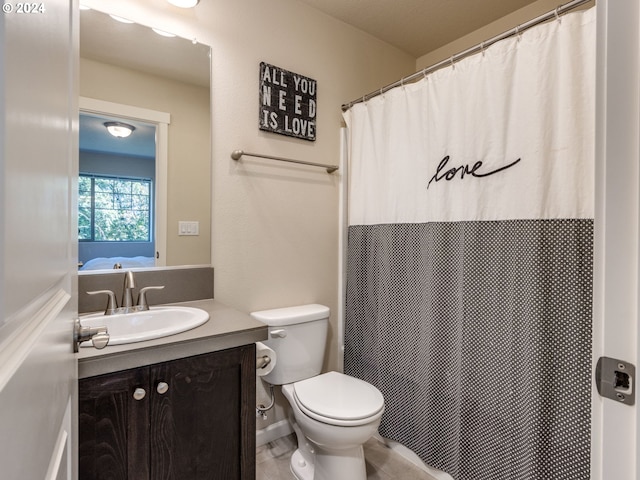 bathroom with tile patterned flooring, vanity, and toilet