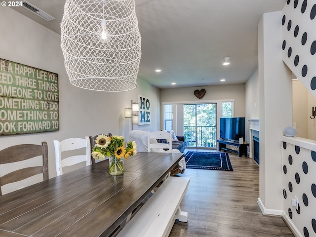 dining space with hardwood / wood-style flooring and a notable chandelier