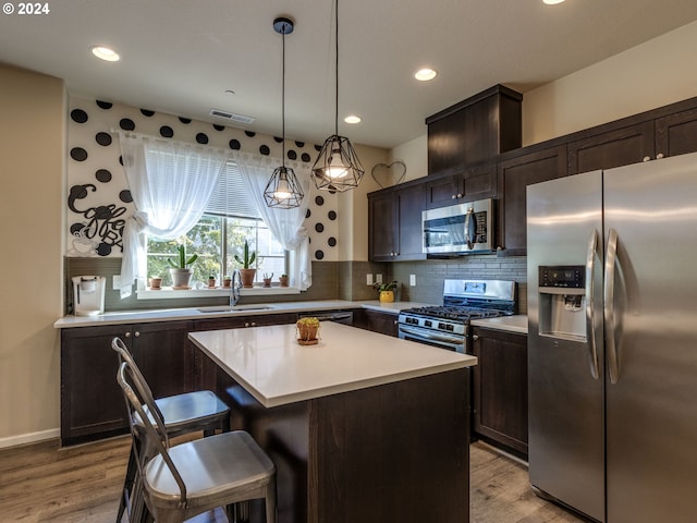 kitchen with a kitchen island, light hardwood / wood-style flooring, appliances with stainless steel finishes, sink, and dark brown cabinetry