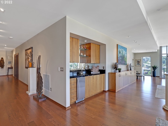 kitchen featuring light brown cabinetry, hardwood / wood-style floors, and sink