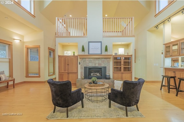 285 23rd St, Astoria, OR 97103 - living room featuring wood finished floors, a towering ceiling, baseboards, and a tiled fireplace