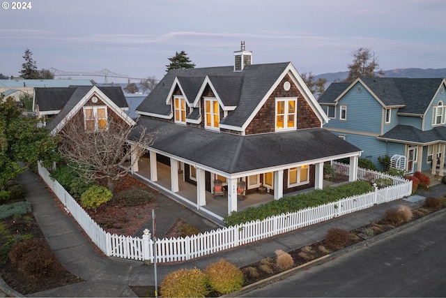285 23rd St, Astoria, OR 97103 - view of front of home featuring covered porch, a chimney, a shingled roof, and a fenced front yard
