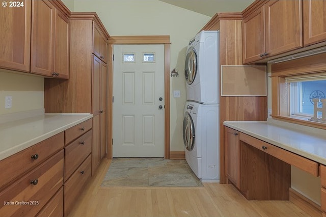 285 23rd St, Astoria, OR 97103 - laundry room featuring stacked washing machine and dryer, cabinet space, light wood-style flooring, and an office area