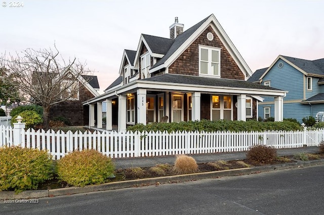 285 23rd St, Astoria, OR 97103 - view of front facade with a porch, a fenced front yard, and a chimney