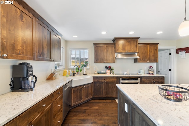 kitchen featuring pendant lighting, stainless steel appliances, sink, and light stone counters