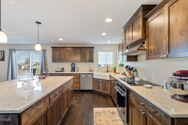 kitchen featuring pendant lighting, stainless steel appliances, a center island, and sink