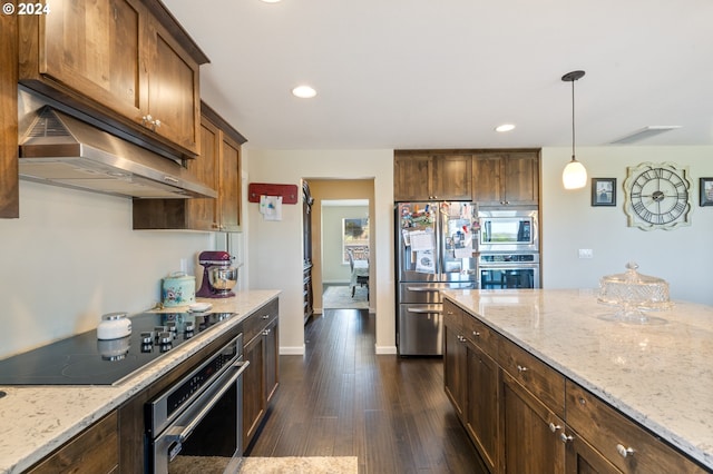 kitchen featuring light stone countertops, appliances with stainless steel finishes, dark hardwood / wood-style floors, and decorative light fixtures