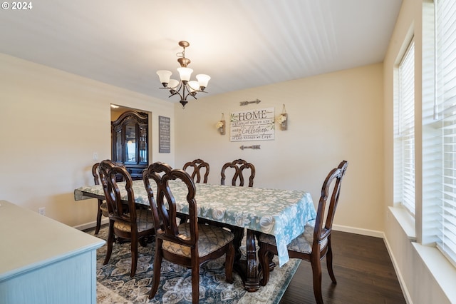 dining room with dark hardwood / wood-style flooring and a chandelier