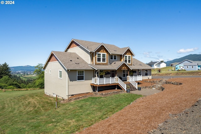 craftsman-style house with a front lawn and a deck with mountain view