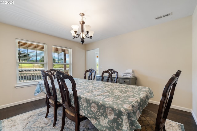 dining space featuring dark hardwood / wood-style floors and a chandelier