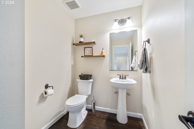 bathroom with hardwood / wood-style floors and toilet