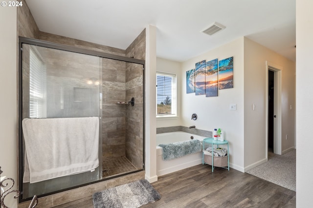 bathroom featuring independent shower and bath and wood-type flooring