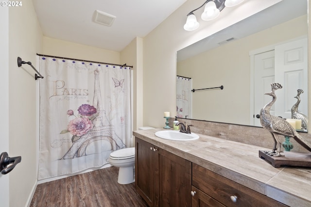 full bathroom featuring wood-type flooring, toilet, shower / tub combo, and vanity