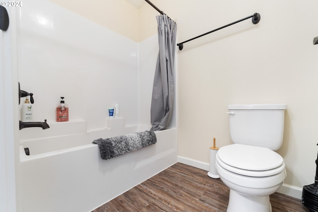 bathroom with hardwood / wood-style floors, shower / tub combo, and toilet