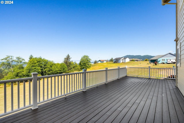 wooden terrace with a mountain view and a yard