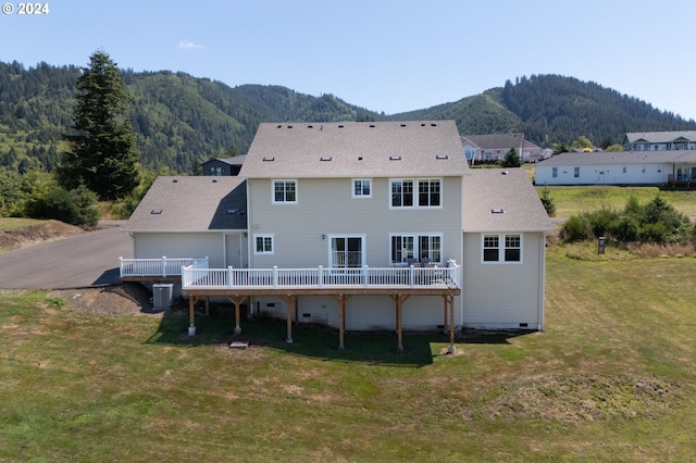 back of property featuring a yard, a deck with mountain view, and central air condition unit