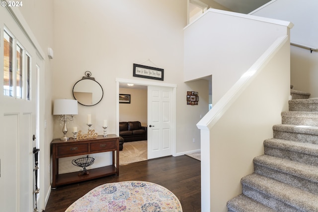 entryway with dark hardwood / wood-style flooring and a high ceiling