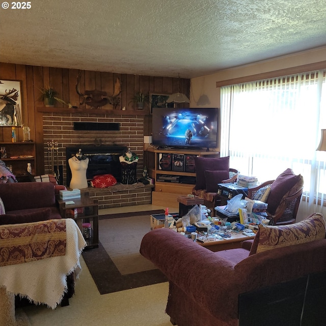 living room featuring a brick fireplace, wooden walls, carpet floors, and a textured ceiling