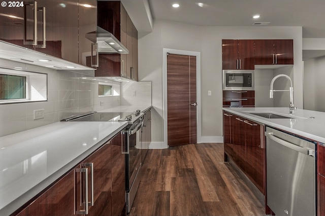 kitchen featuring wall chimney range hood, sink, dark hardwood / wood-style flooring, appliances with stainless steel finishes, and tasteful backsplash