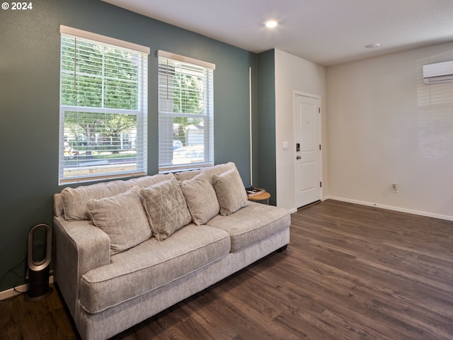 living room with dark hardwood / wood-style flooring and a wall unit AC