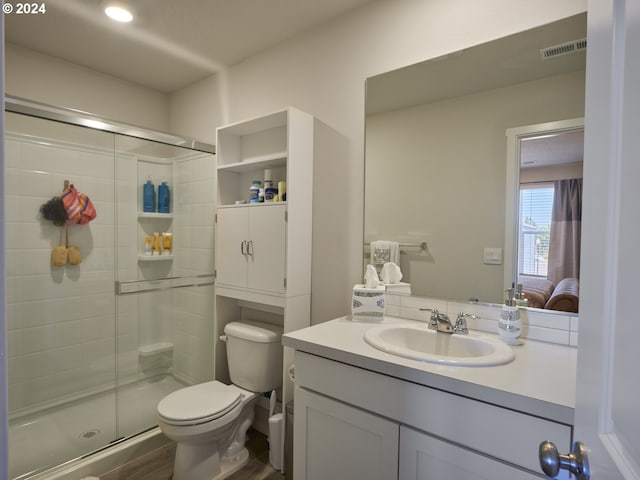 bathroom with vanity, wood-type flooring, a shower with shower door, and toilet