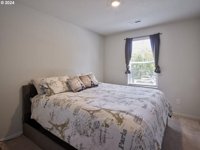 bedroom featuring carpet flooring and a textured ceiling