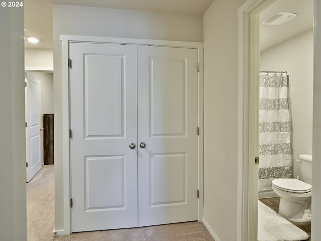 bathroom with a shower with shower curtain and toilet