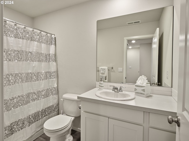 full bathroom featuring hardwood / wood-style flooring, vanity, toilet, and shower / tub combo