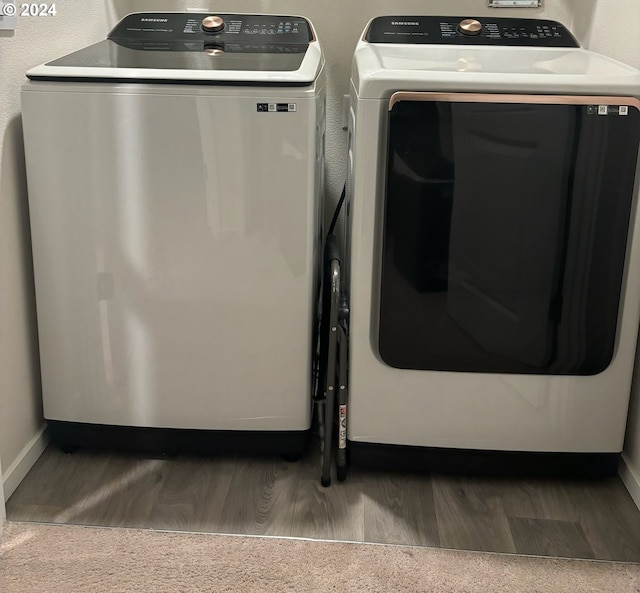 washroom with washer and clothes dryer and hardwood / wood-style flooring