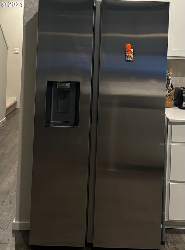 room details with white cabinets, stainless steel fridge with ice dispenser, and dark wood-type flooring