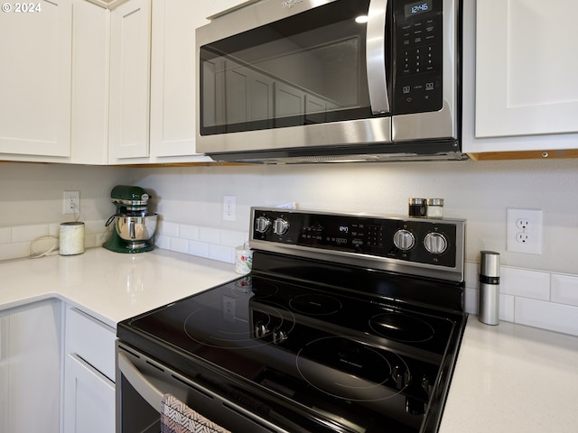 kitchen featuring electric range and white cabinetry