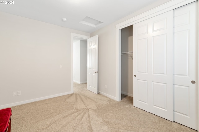 unfurnished bedroom featuring light carpet and a closet