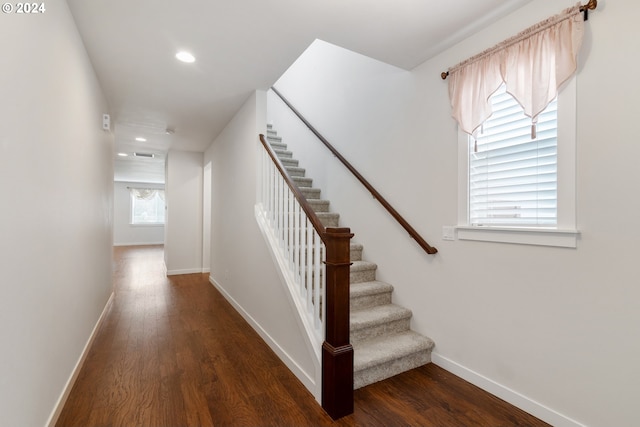 stairway with a healthy amount of sunlight and wood-type flooring