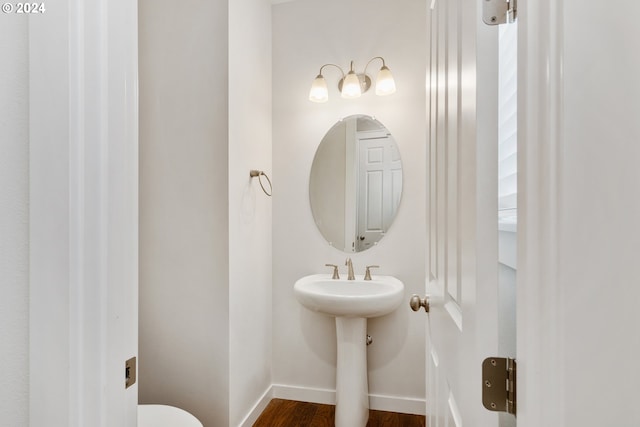 bathroom featuring wood-type flooring and toilet