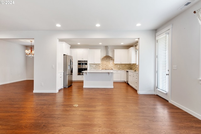 kitchen featuring white cabinets, stainless steel appliances, wall chimney range hood, and light hardwood / wood-style flooring