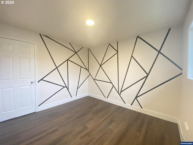 unfurnished room with dark hardwood / wood-style flooring