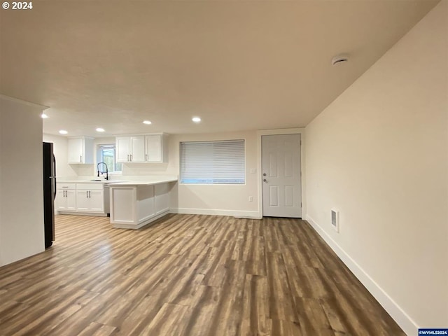 unfurnished living room featuring light hardwood / wood-style flooring and sink