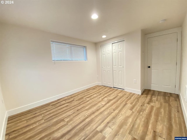 unfurnished bedroom with a closet and light hardwood / wood-style flooring