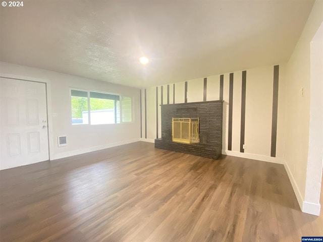 unfurnished living room with a brick fireplace and hardwood / wood-style floors