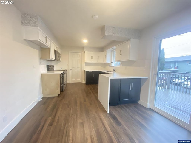 kitchen with black range with electric stovetop, sink, kitchen peninsula, dark wood-type flooring, and white cabinetry