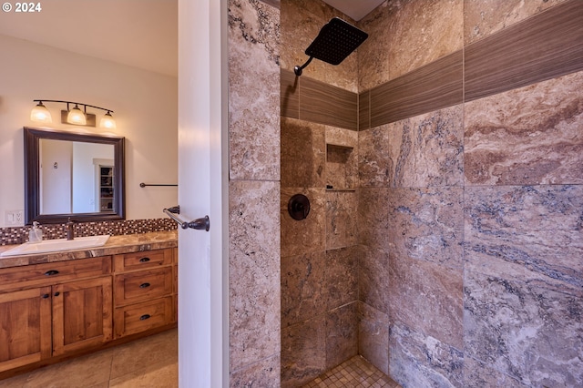 bathroom featuring vanity, a tile shower, and tile patterned flooring