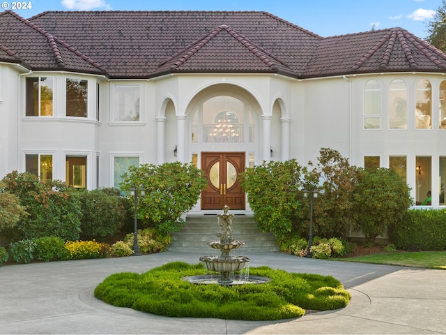 exterior space with concrete driveway, a tiled roof, and stucco siding