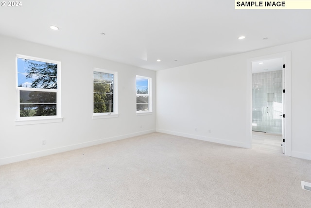 spare room with light colored carpet, recessed lighting, and baseboards