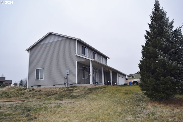 view of side of property featuring a yard, covered porch, and a garage