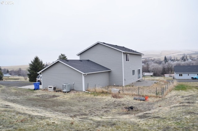 view of side of home with a mountain view and central AC