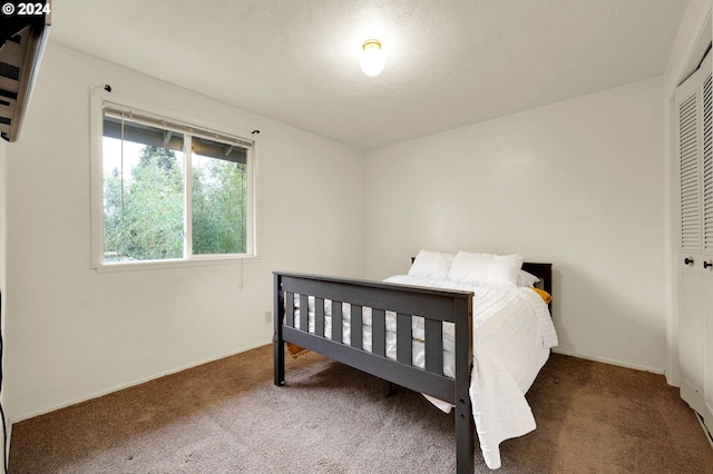 bedroom featuring a closet and dark colored carpet